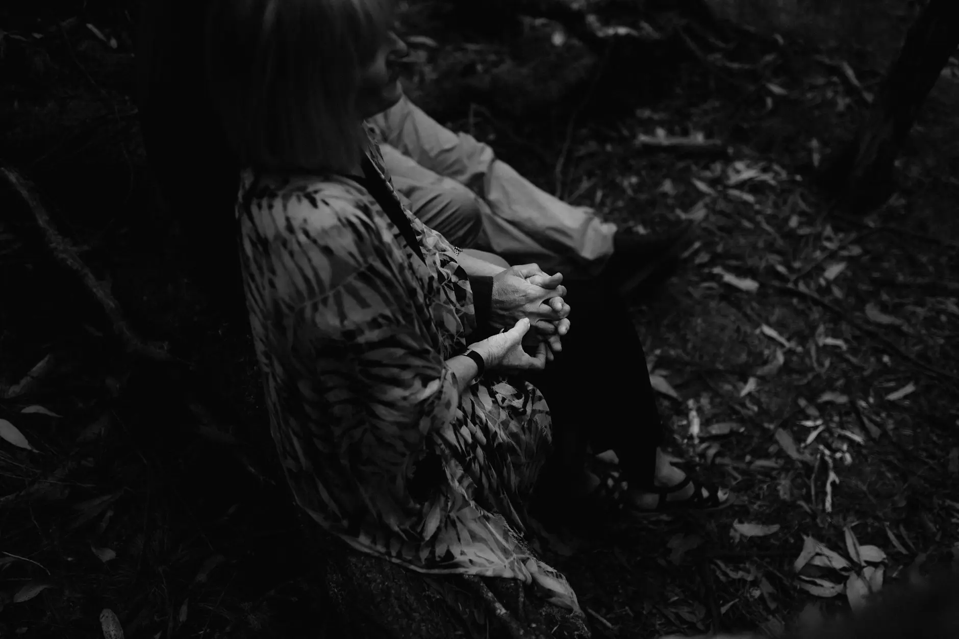 Hands clasped low during the ceremony, black and white, New England