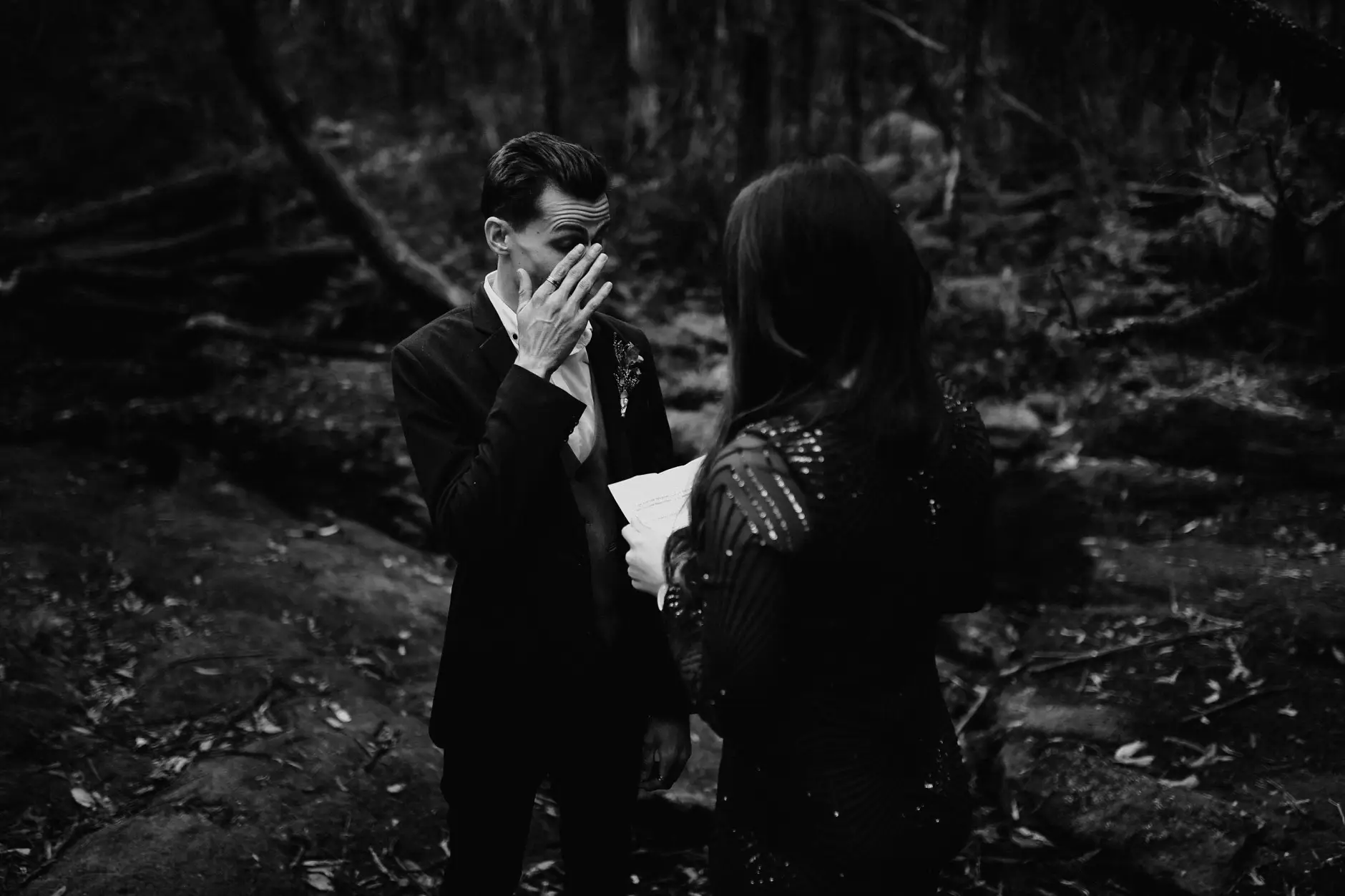 Drew covering his face with emotion during the vows, black and white