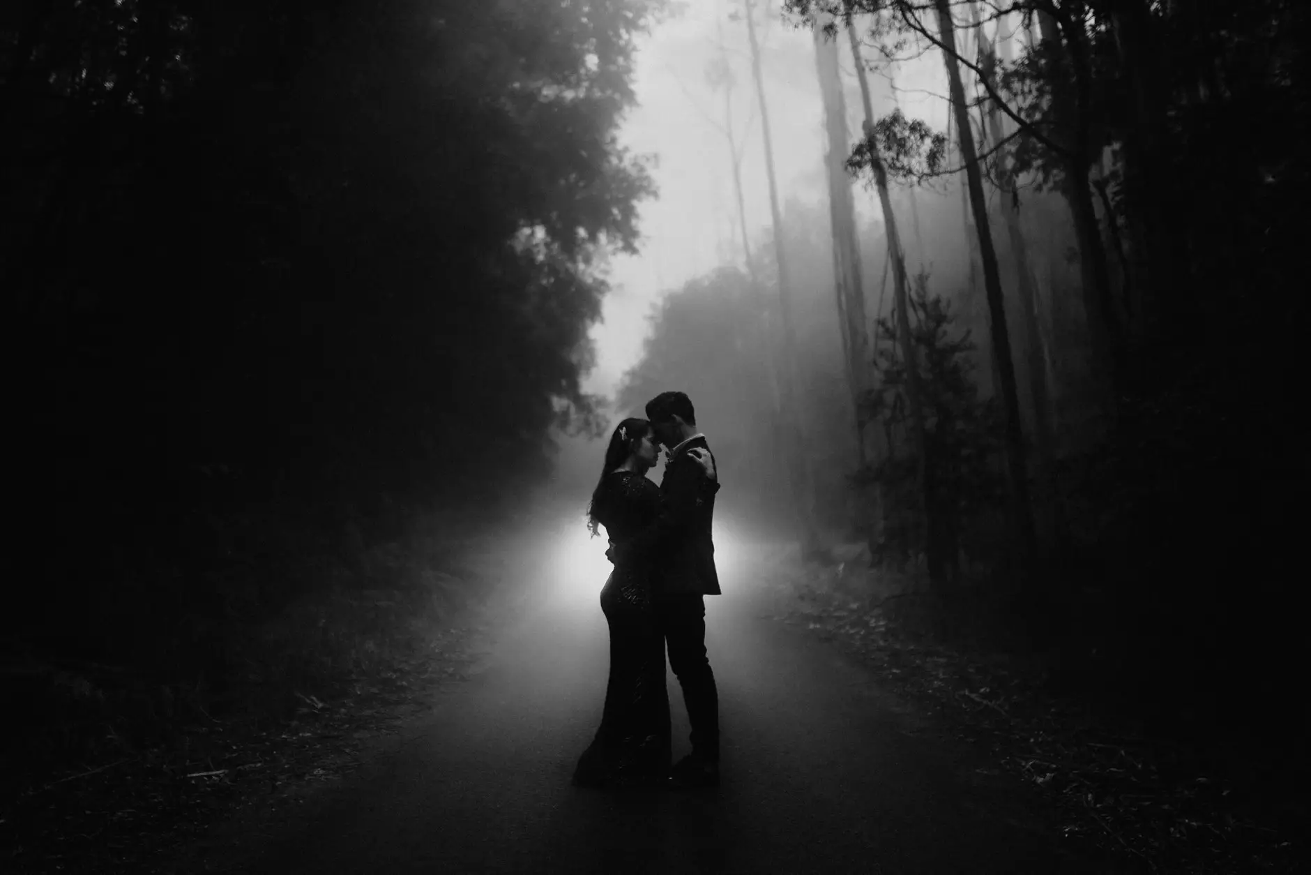 Jess and Drew silhouetted in the fog on the road, black and white