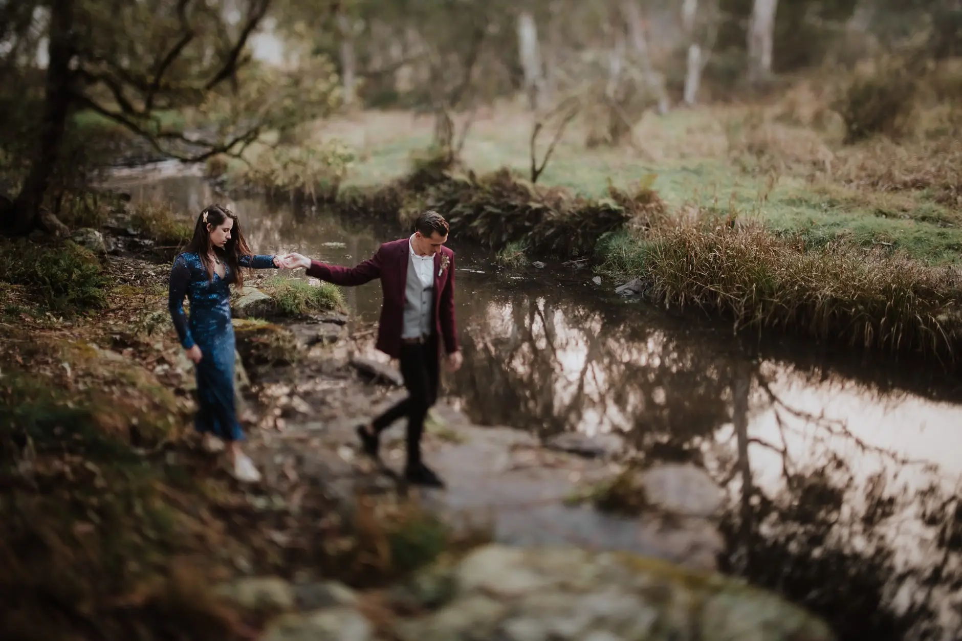 Jess and Drew crossing the creek hand in hand, New England