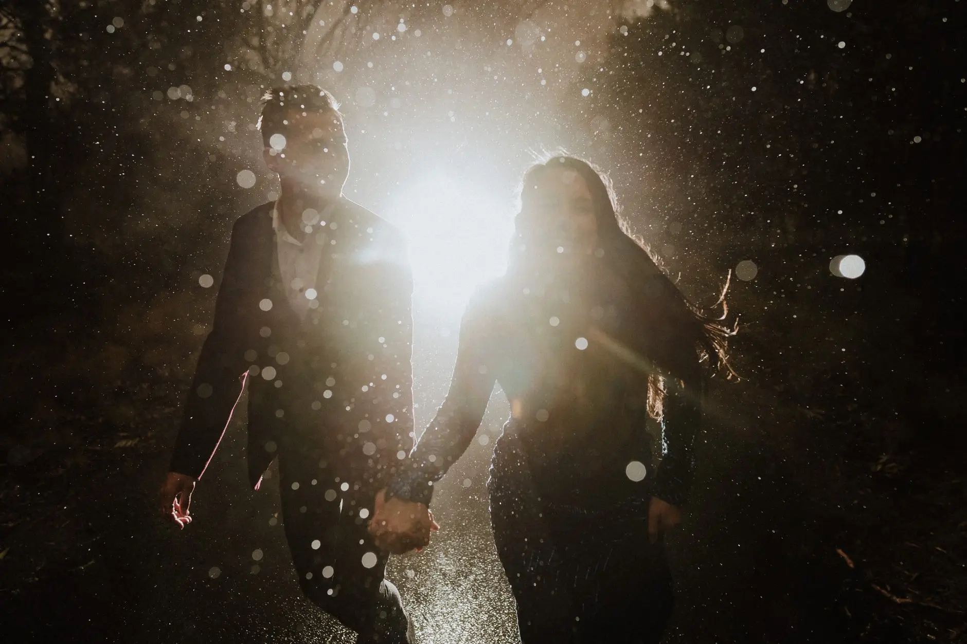Silhouetted hand in hand in the backlit rain, New England