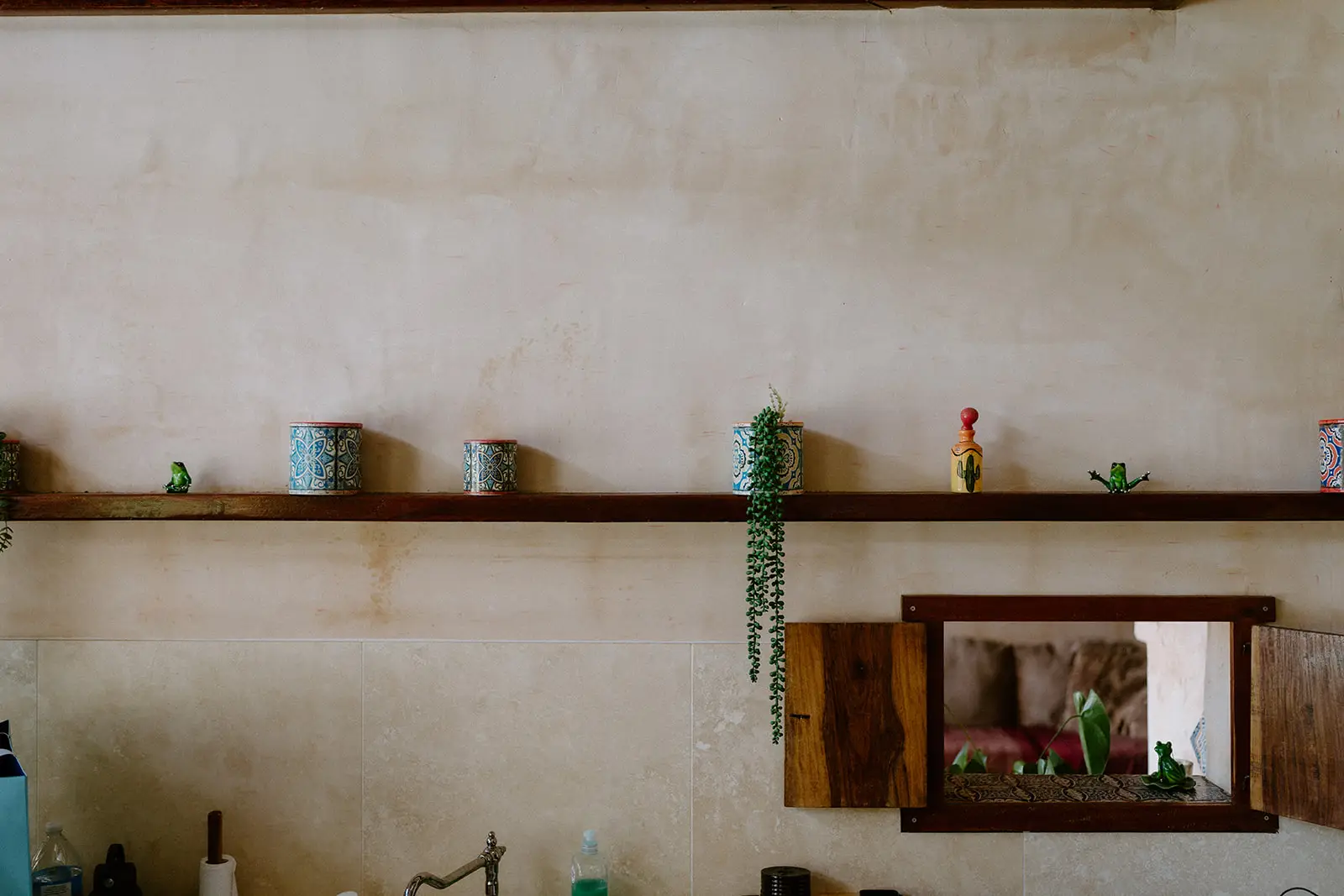 A shelf of small ceramics against the stucco wall inside the villa, Nutting Hill Villa