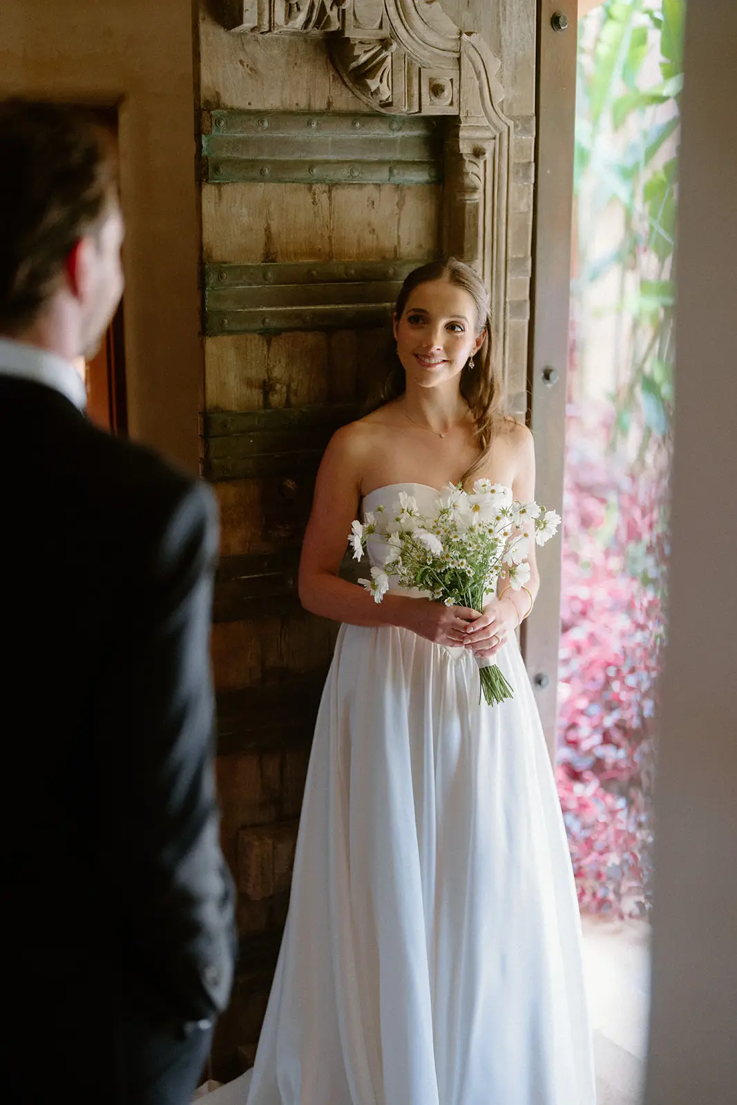 The couple in an old timber doorway with bougainvillea behind, Nutting Hill Villa