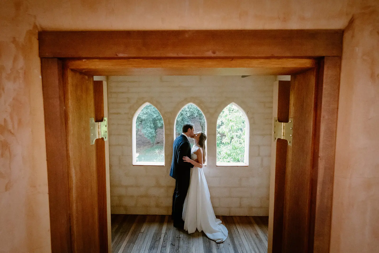 Framed by the timber doorway, the couple at the arched windows beyond, Nutting Hill Villa
