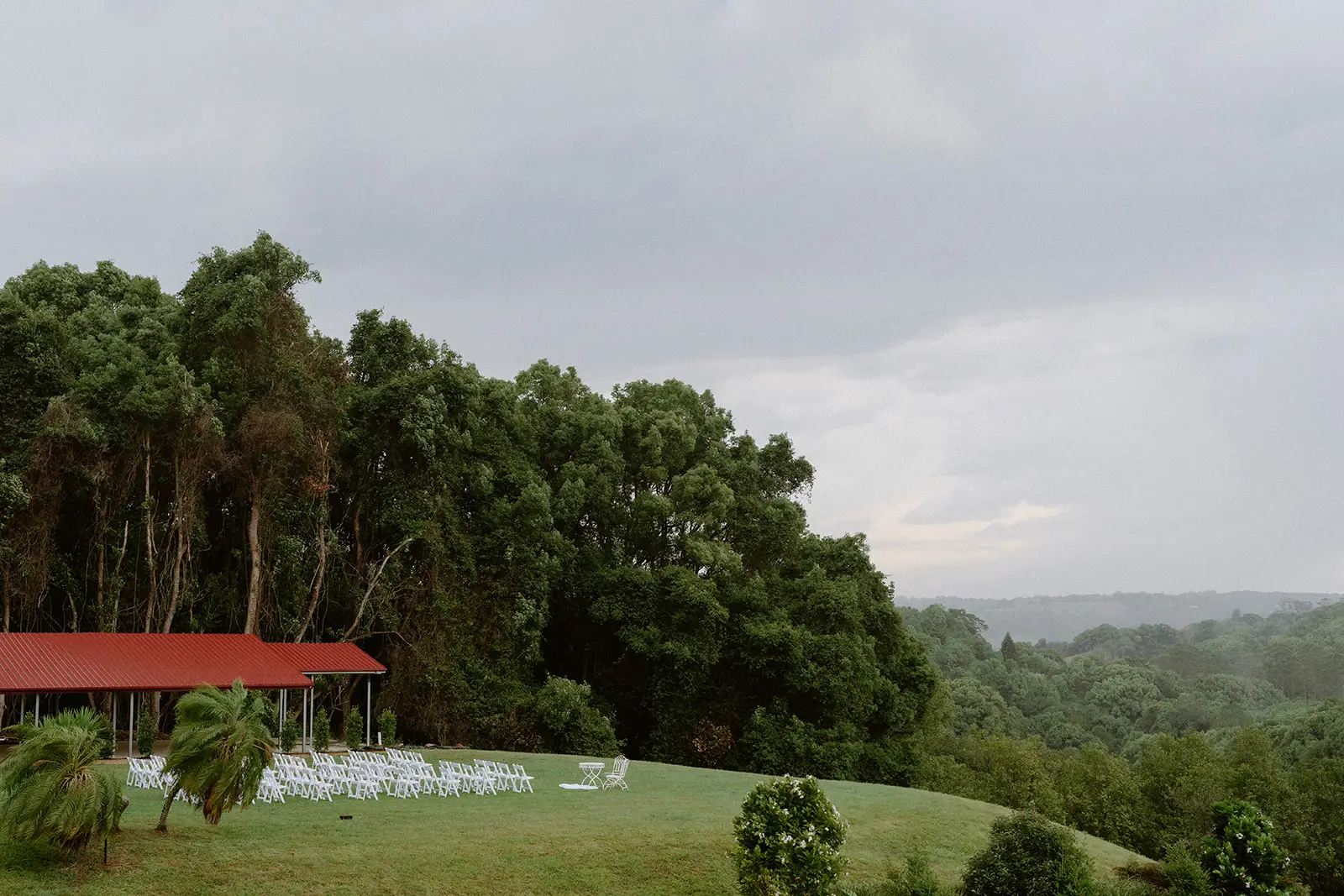 The open-sided pavilion set with white chairs on the lawn above the valley, Nutting Hill Villa, Clunes