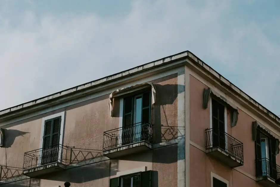 A pink Amalfi building with green shutters and iron balconies