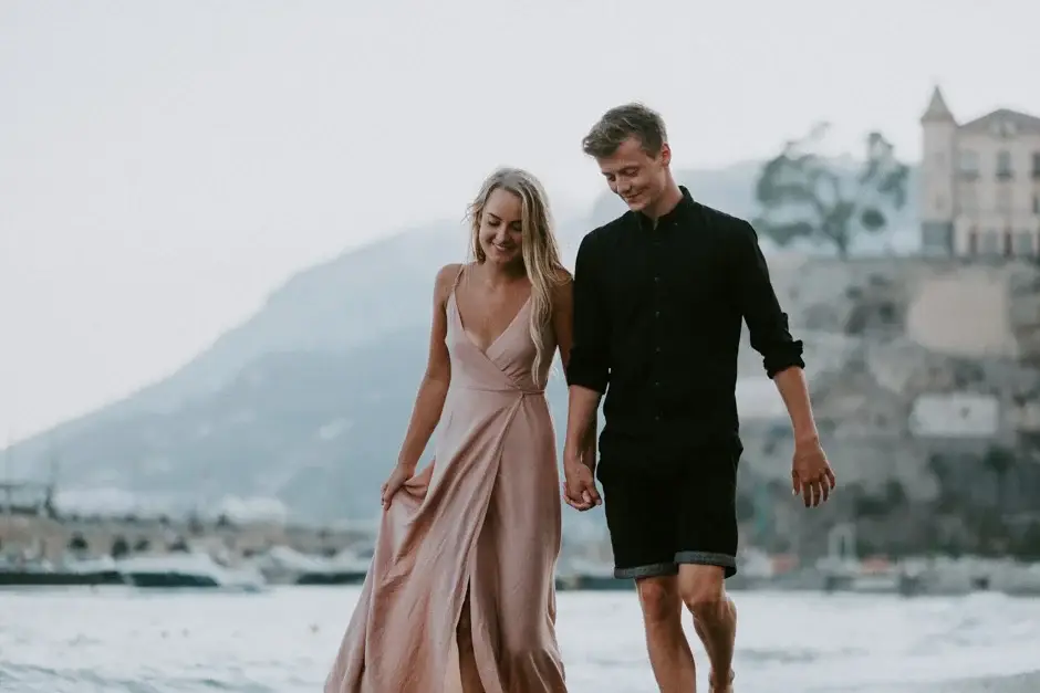 Emilie and Henrik walking the shore with the headland behind