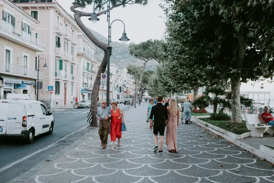 Walking a busy Amalfi street lined with plane trees