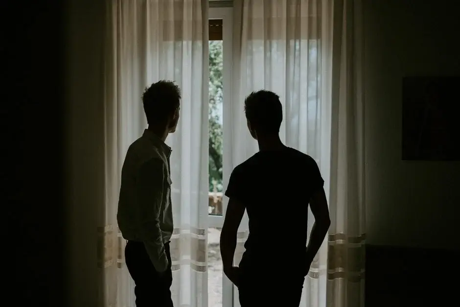 Henrik and a friend silhouetted at the window before the wedding