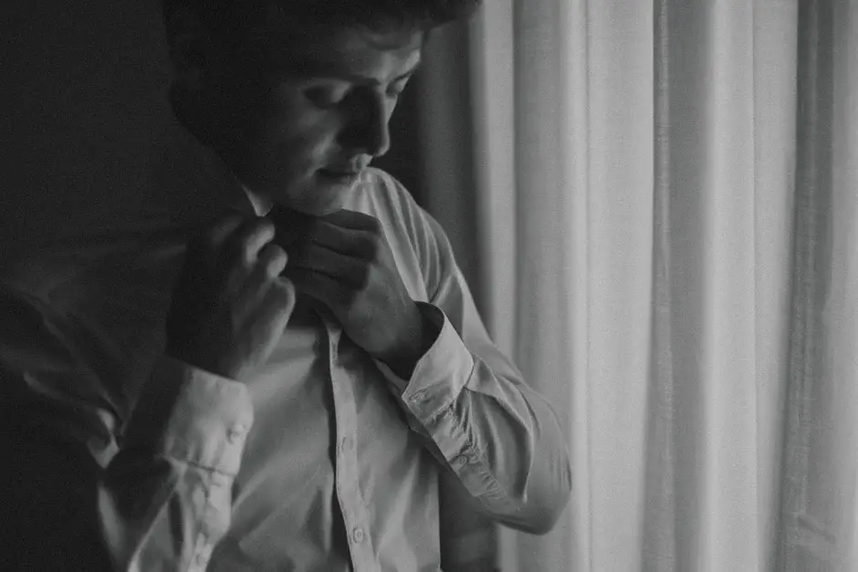 Henrik fastening his collar, black and white, Ravello