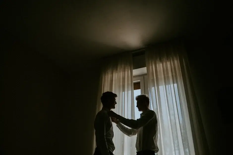A friend helping Henrik with his bow tie at the window
