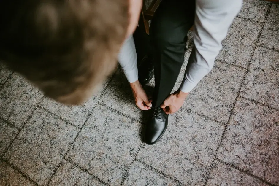 Tying his shoelaces on the stone floor seen from above, Ravello