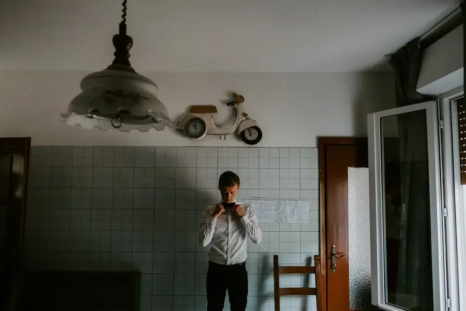 Henrik standing in a green-tiled kitchen with a Vespa outside