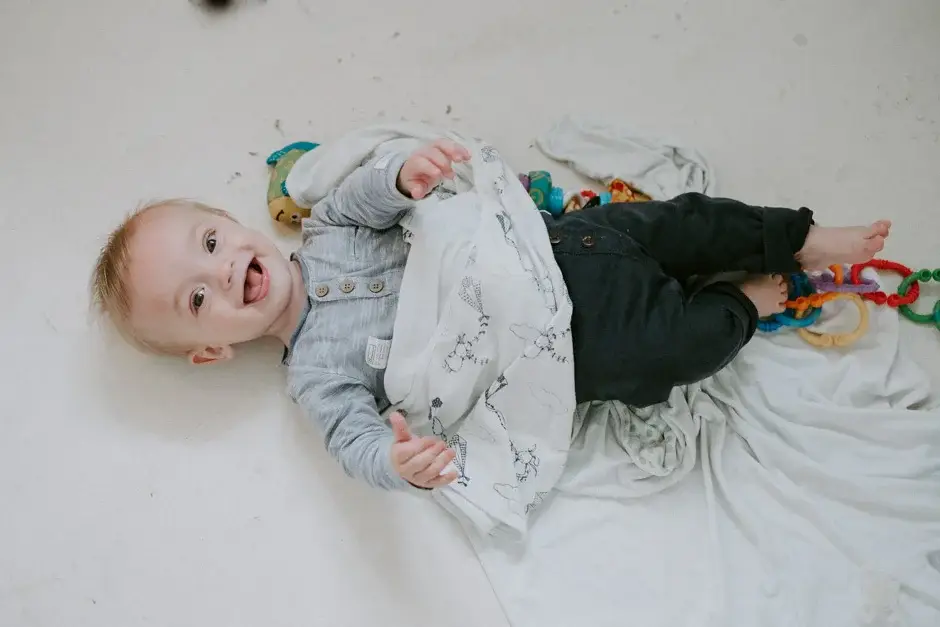 A baby lying on the bed with a toy, Ravello