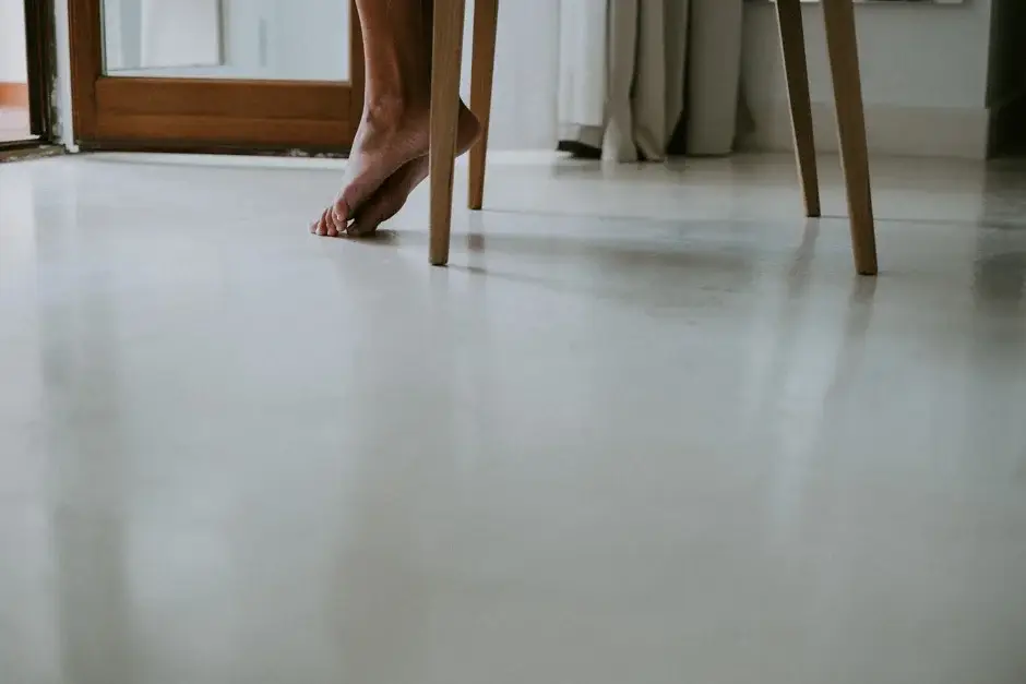 Bare feet beneath a chair on a white floor, Ravello