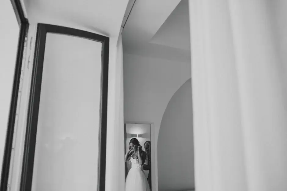 Emilie glimpsed through a doorway in her gown, black and white