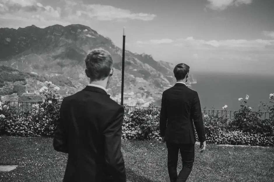 Two men looking out over the coast from the garden, black and white