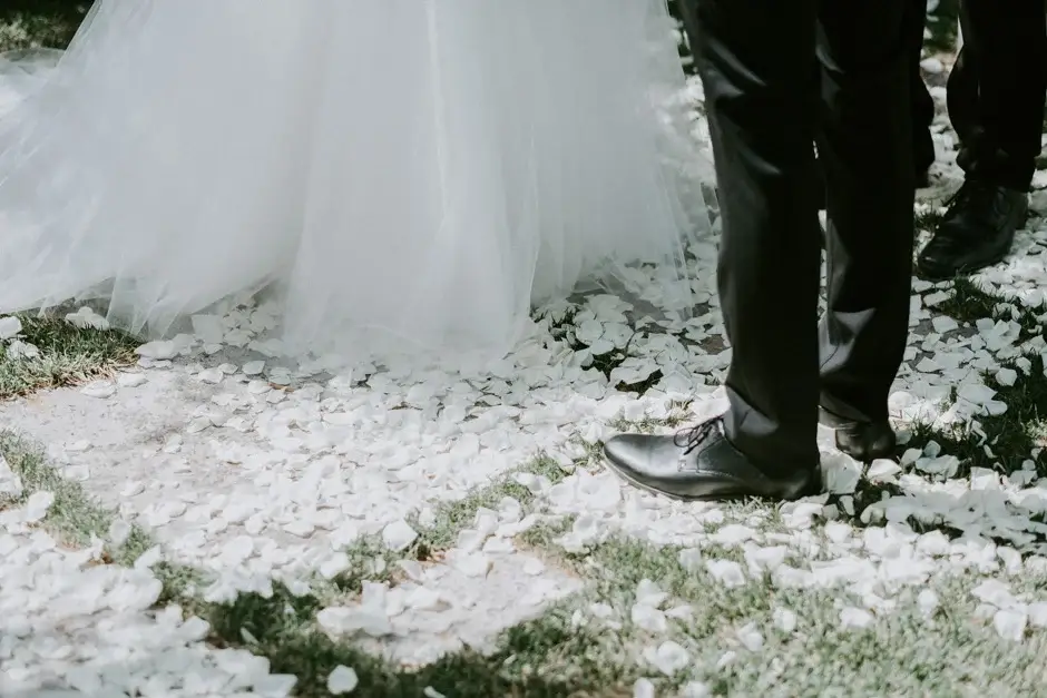 The hem of her gown and his shoes on the petal-strewn path