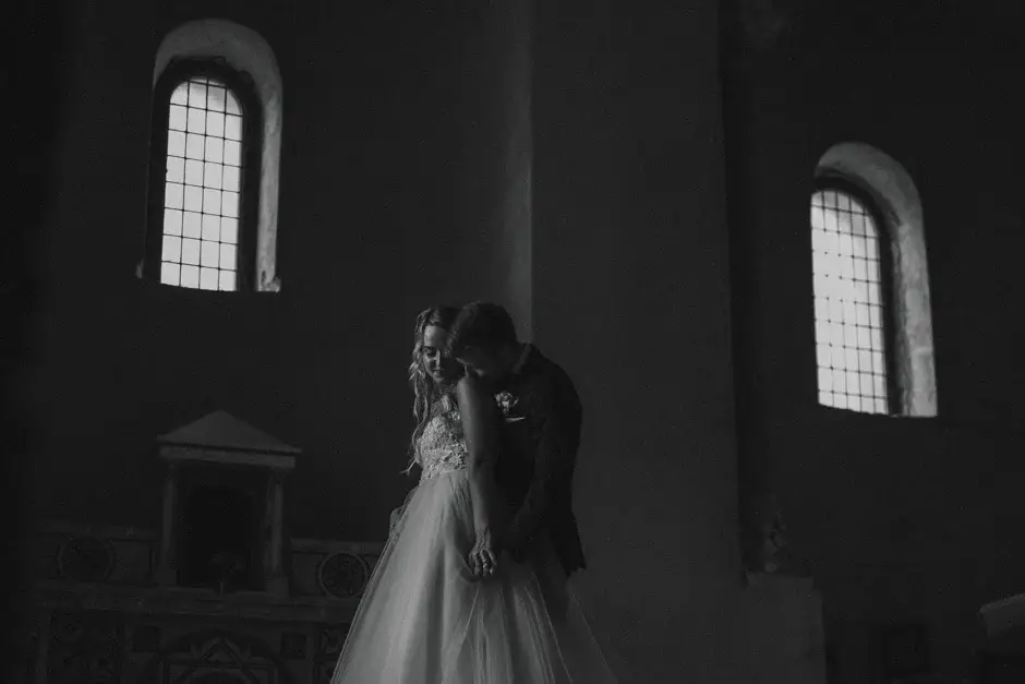 Emilie and Henrik in a shadowy stone room, black and white