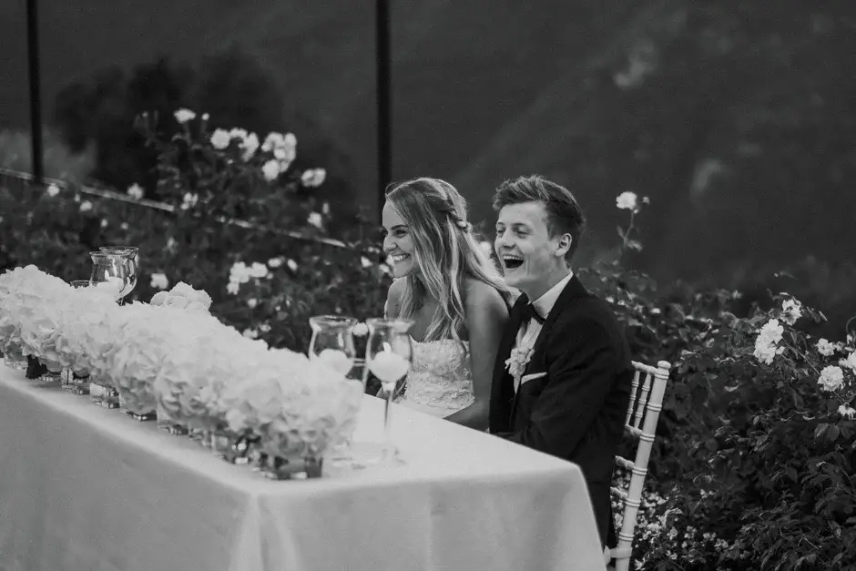Emilie and Henrik laughing at the head table, black and white