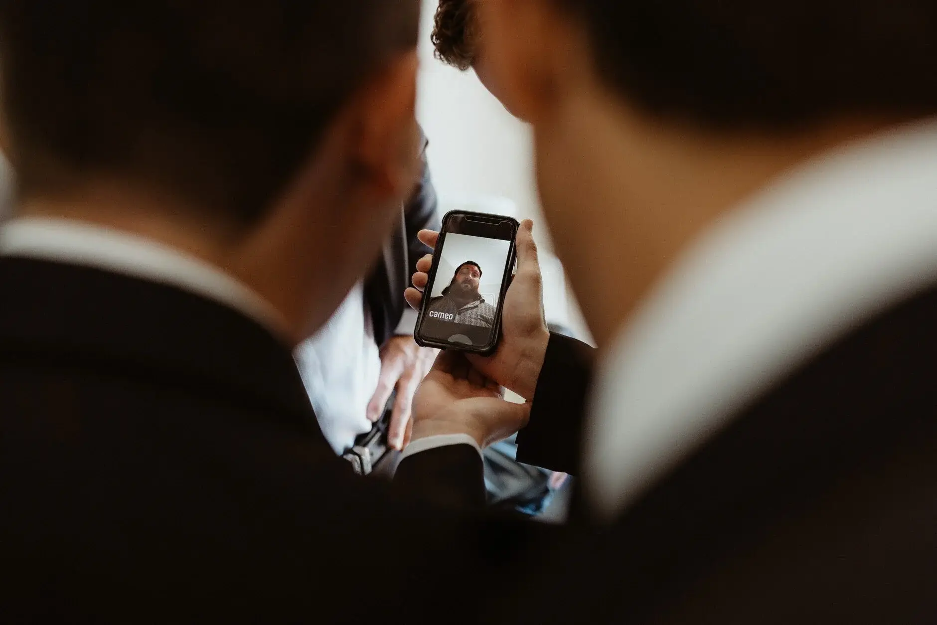 James showing the groomsmen a photo on his phone before the wedding