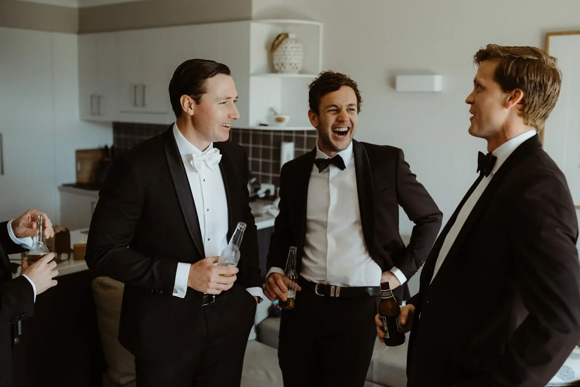 Three of the groomsmen laughing together before the wedding