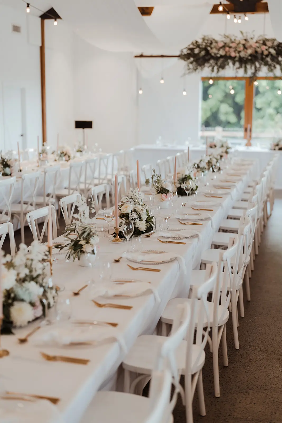 Long tables set inside the barn beneath the festoons, Summergrove Estate