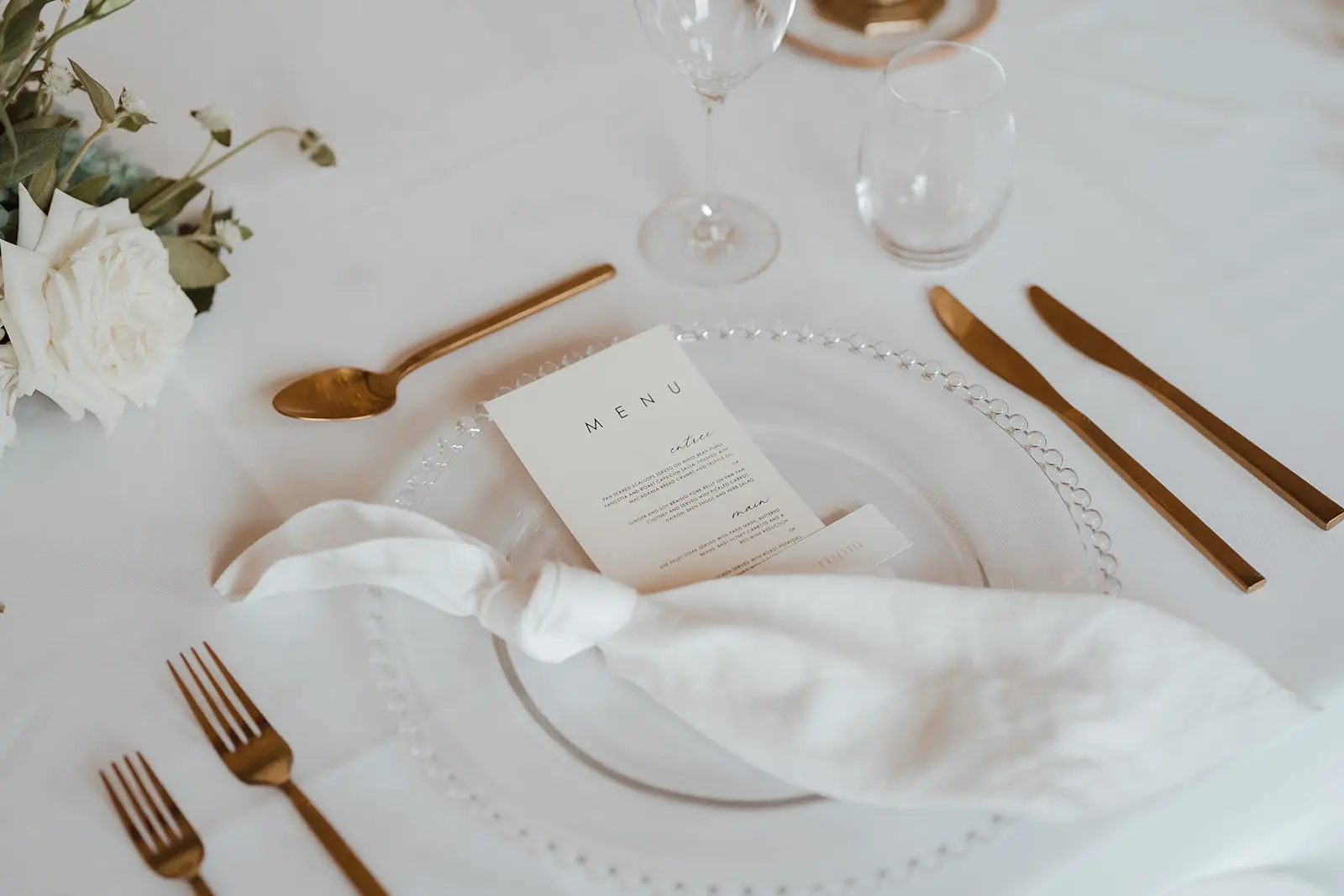 A place setting with gold cutlery and a printed menu, Summergrove Estate