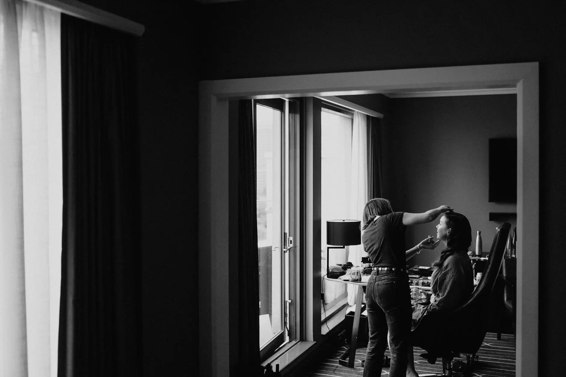 A dark hotel room with the Sydney skyline through the window on the morning of the wedding
