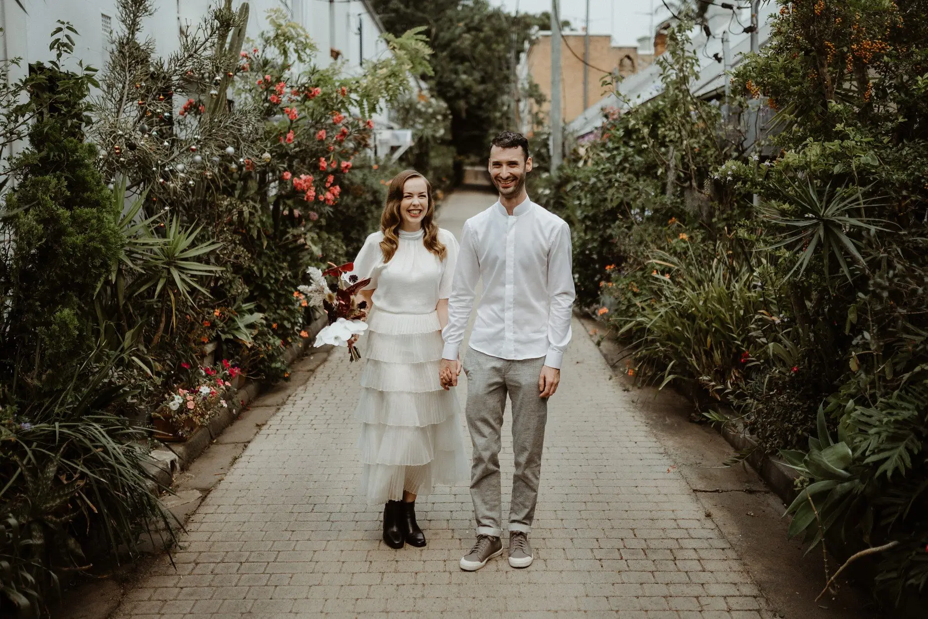 Sophie and Jonathan walking towards the camera down a green Surry Hills alleyway