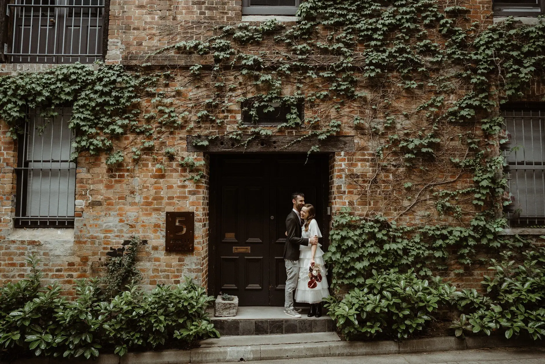 Sophie in the doorway of an ivy-covered brick building, Surry Hills