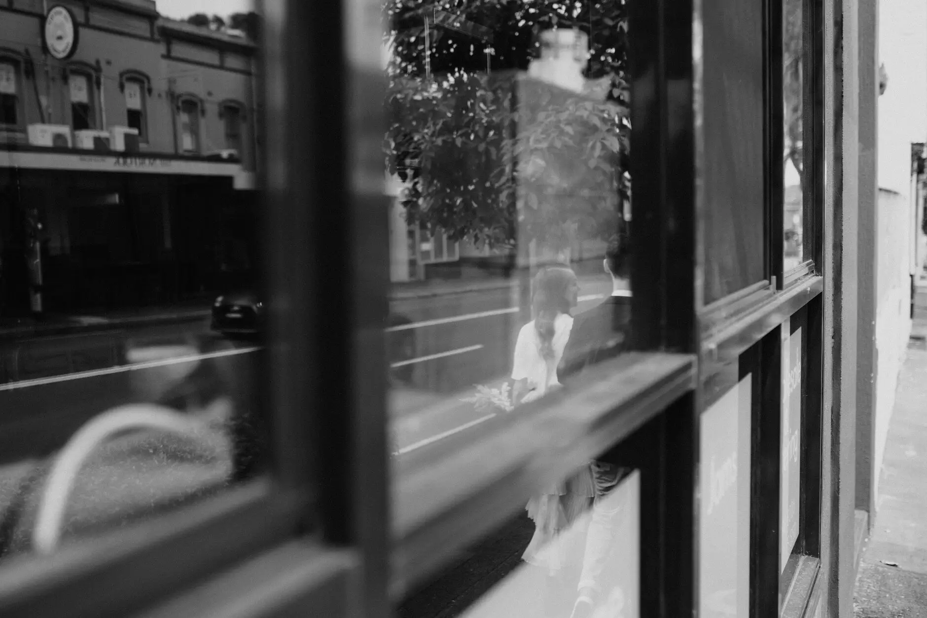 The street reflected in a car window with the couple inside, Sydney