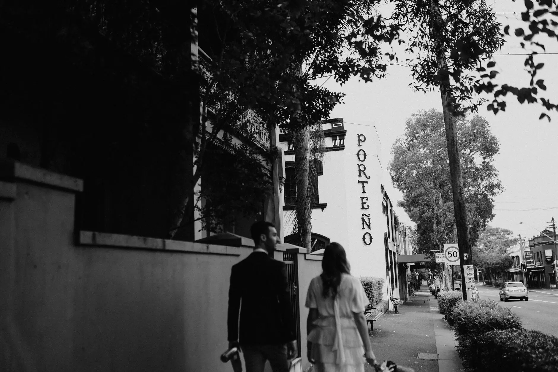 Sophie and Jonathan walking down the street towards the Porteño sign, Surry Hills