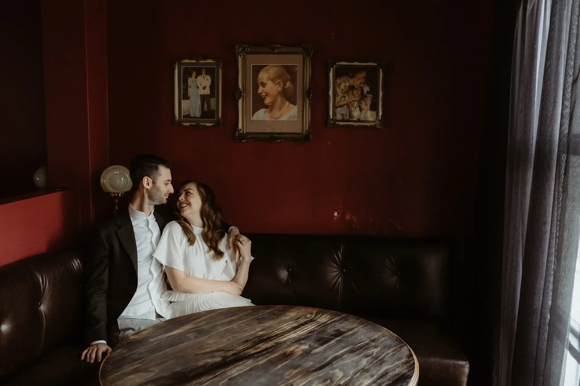 Sophie and Jonathan on the banquette behind a round timber table, Casa, Surry Hills