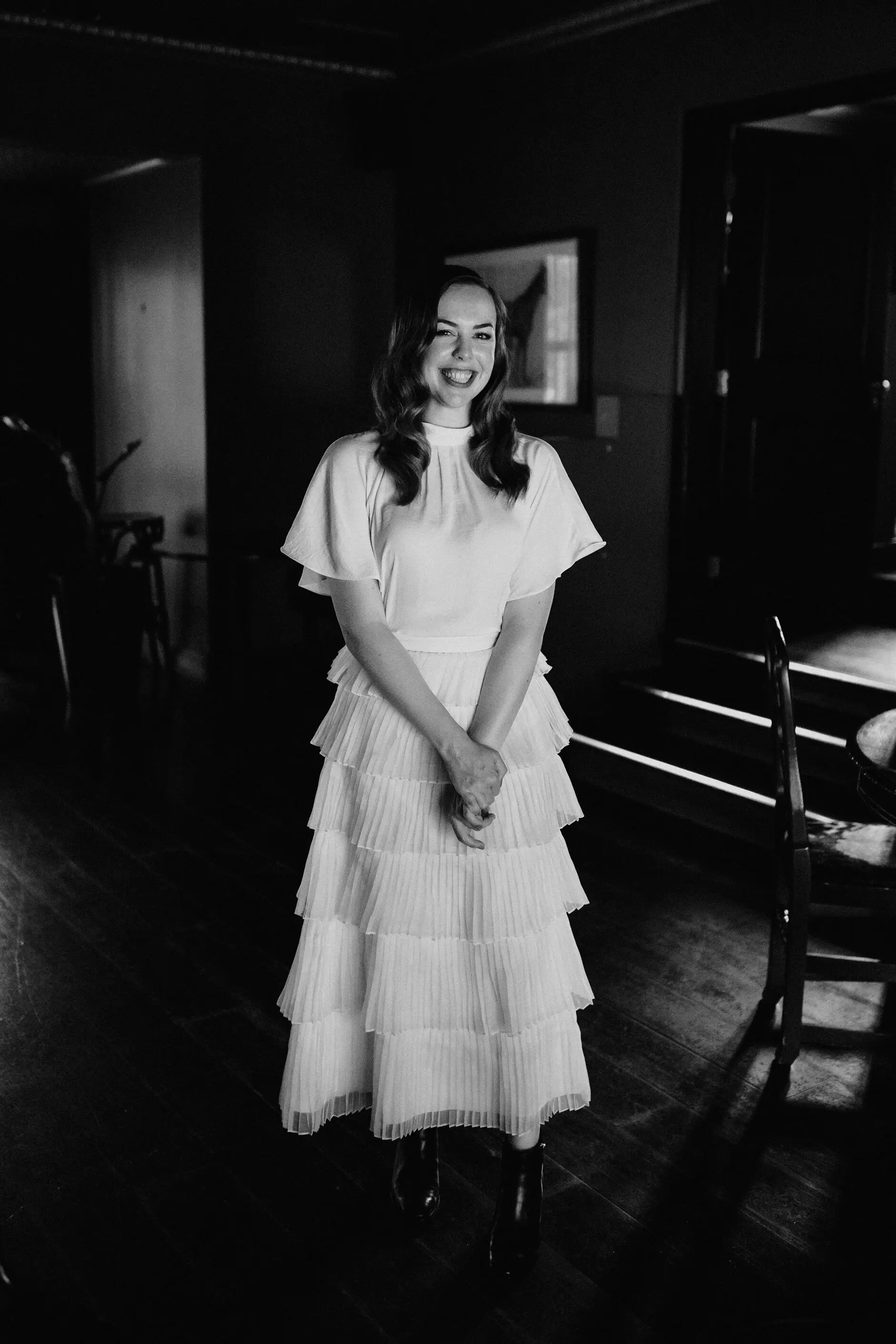 Sophie standing in the doorway in her tiered dress, in black and white, Surry Hills