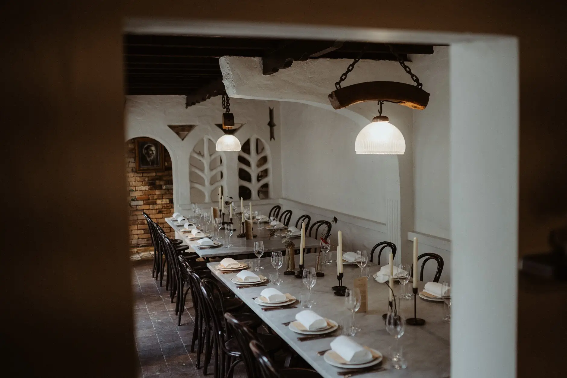 The long table set under the brick arches and pendant lights at Porteño, Surry Hills