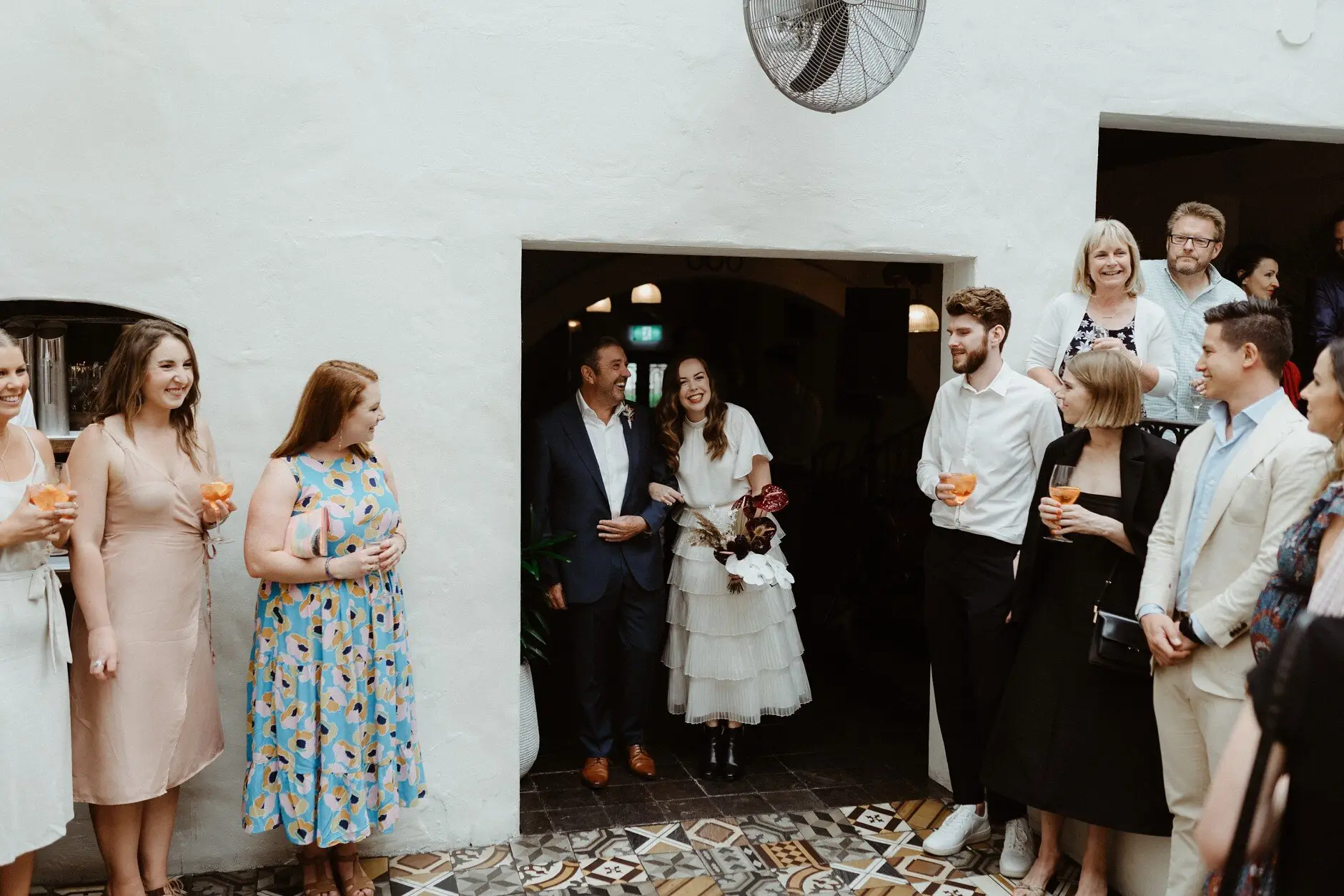 Guests standing with drinks in the doorway before the ceremony, Porteño, Surry Hills