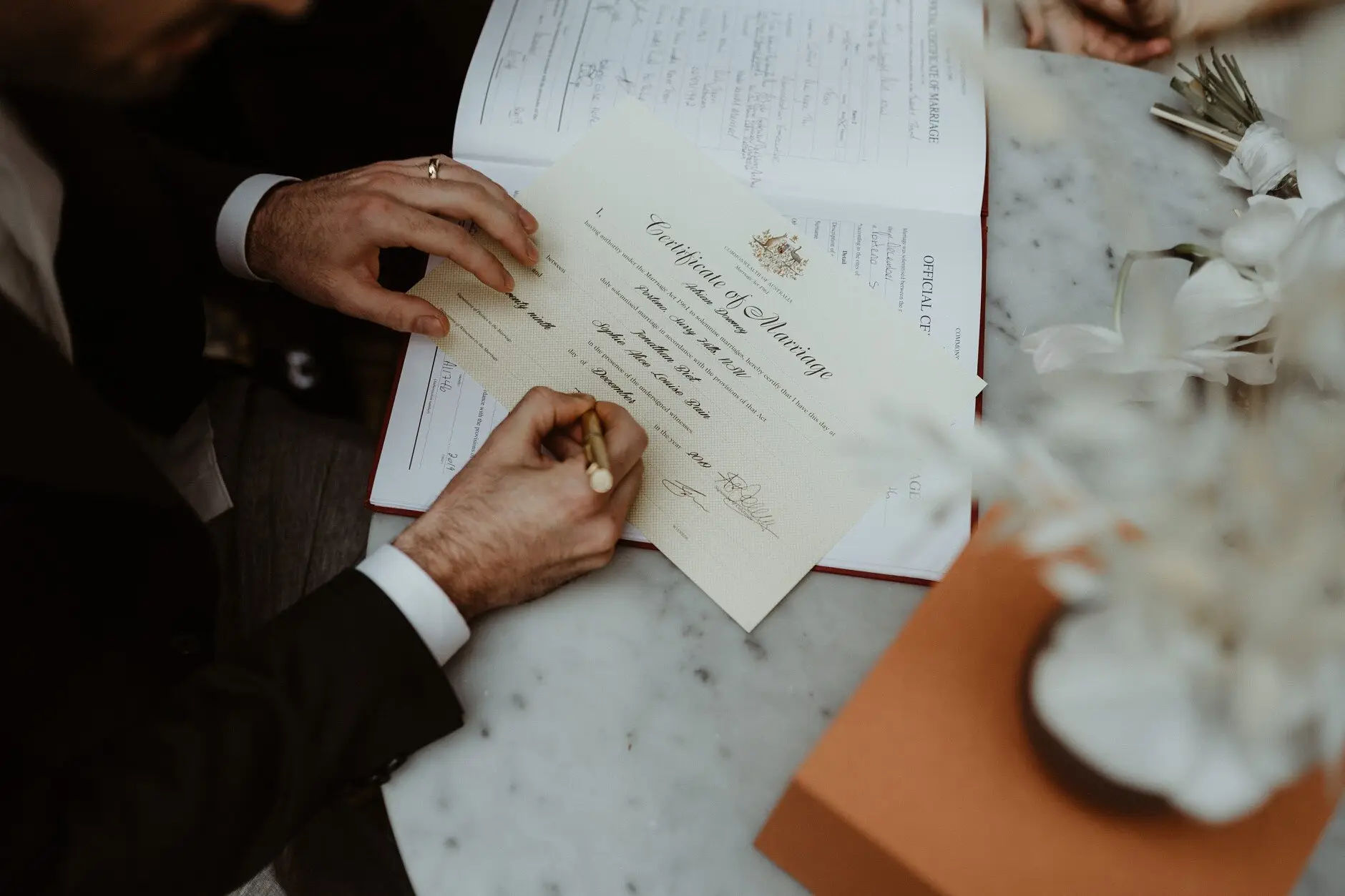 Hands signing the marriage certificate on the marble, Porteño, Surry Hills