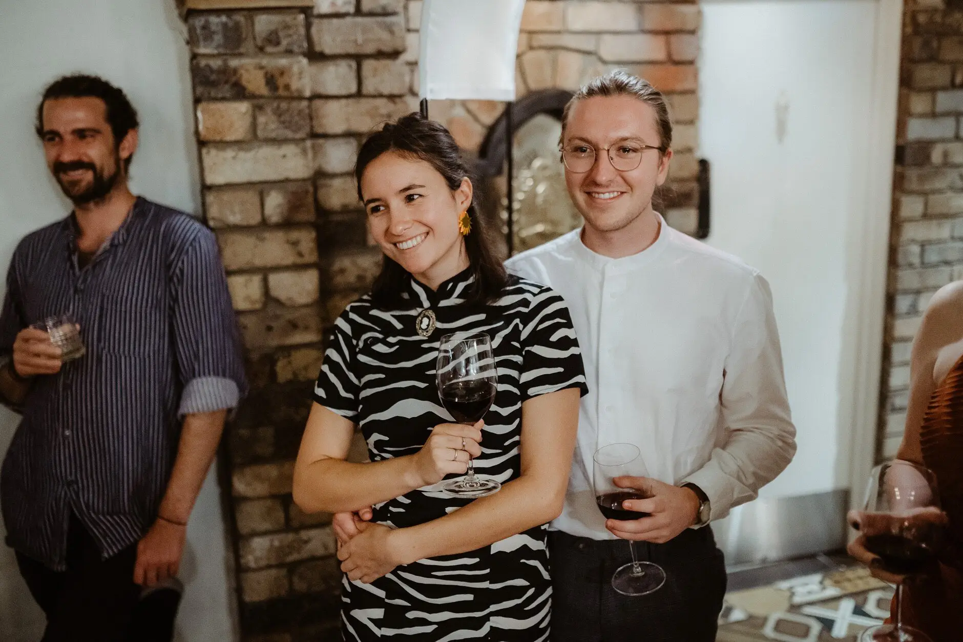 Three guests with their wine against the brick wall, Porteño, Surry Hills