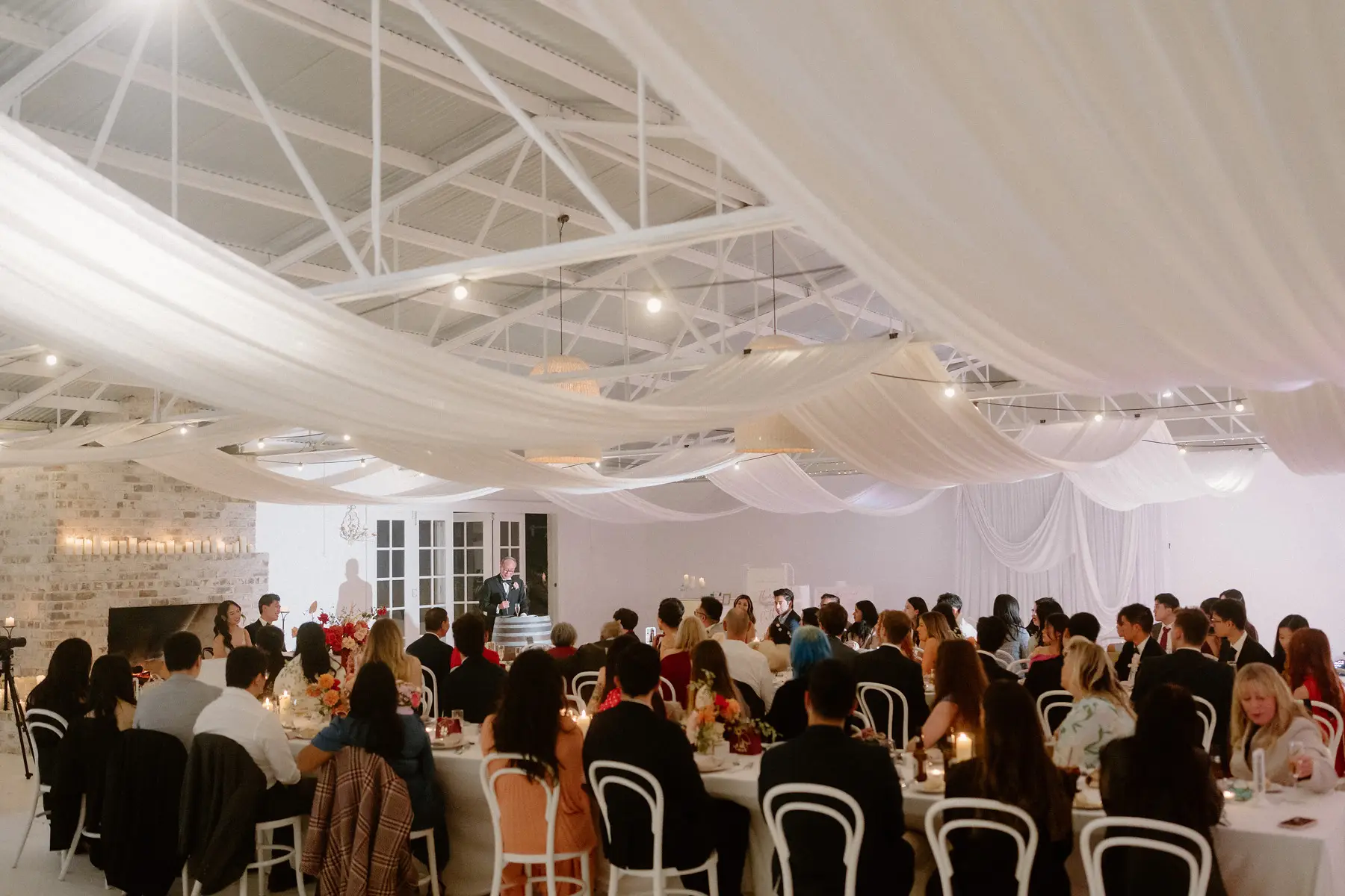 The reception under the draped ceiling of the pavilion, every table full, Tall Trees Tallebudgera Valley