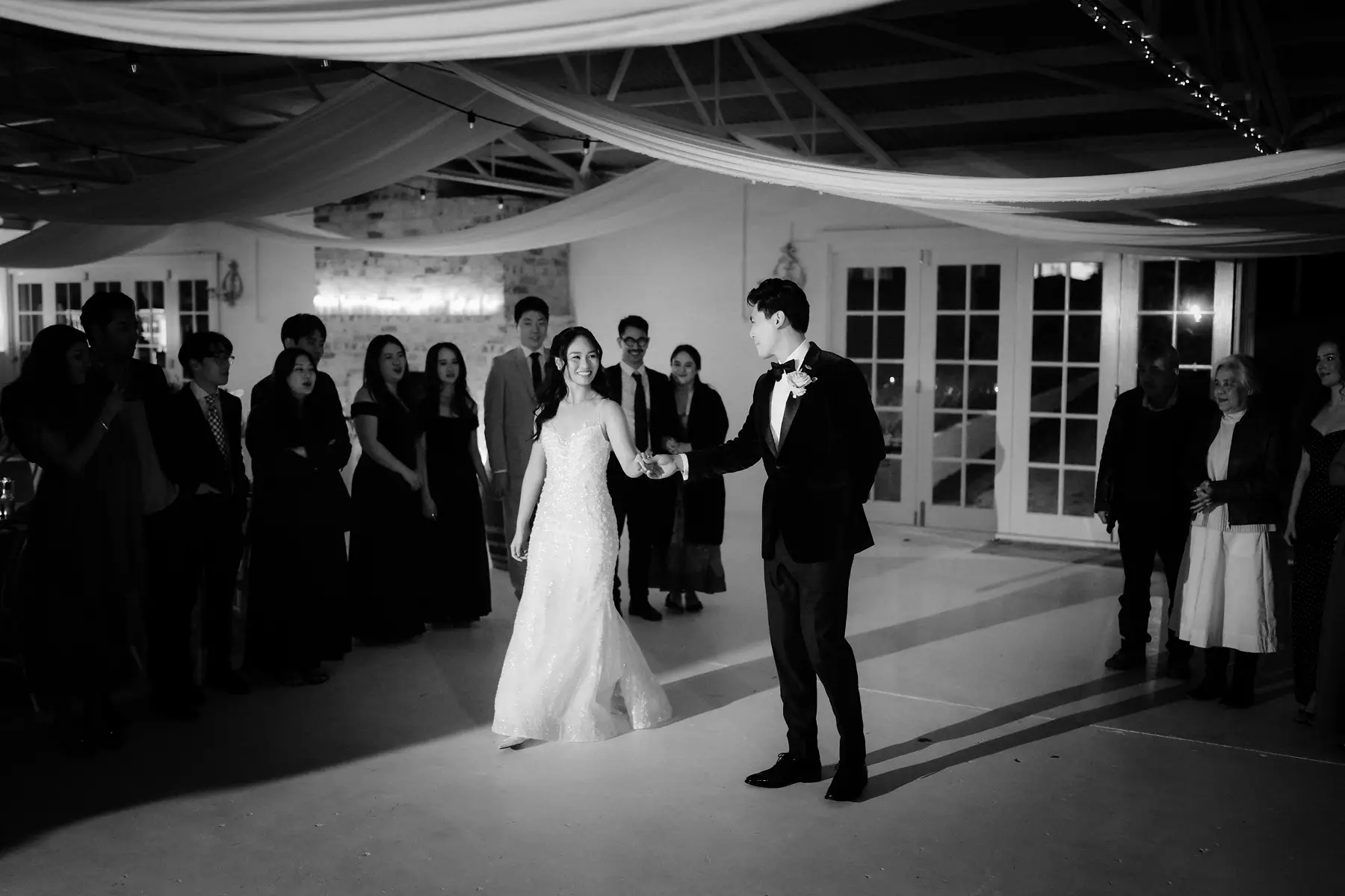 The first dance beginning, guests ringed around the floor, in black and white, Tall Trees Tallebudgera Valley