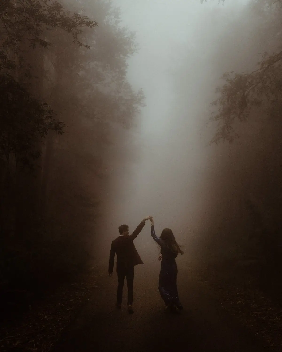 A couple dancing on a fog-filled road through the rainforest, Tweed Valley