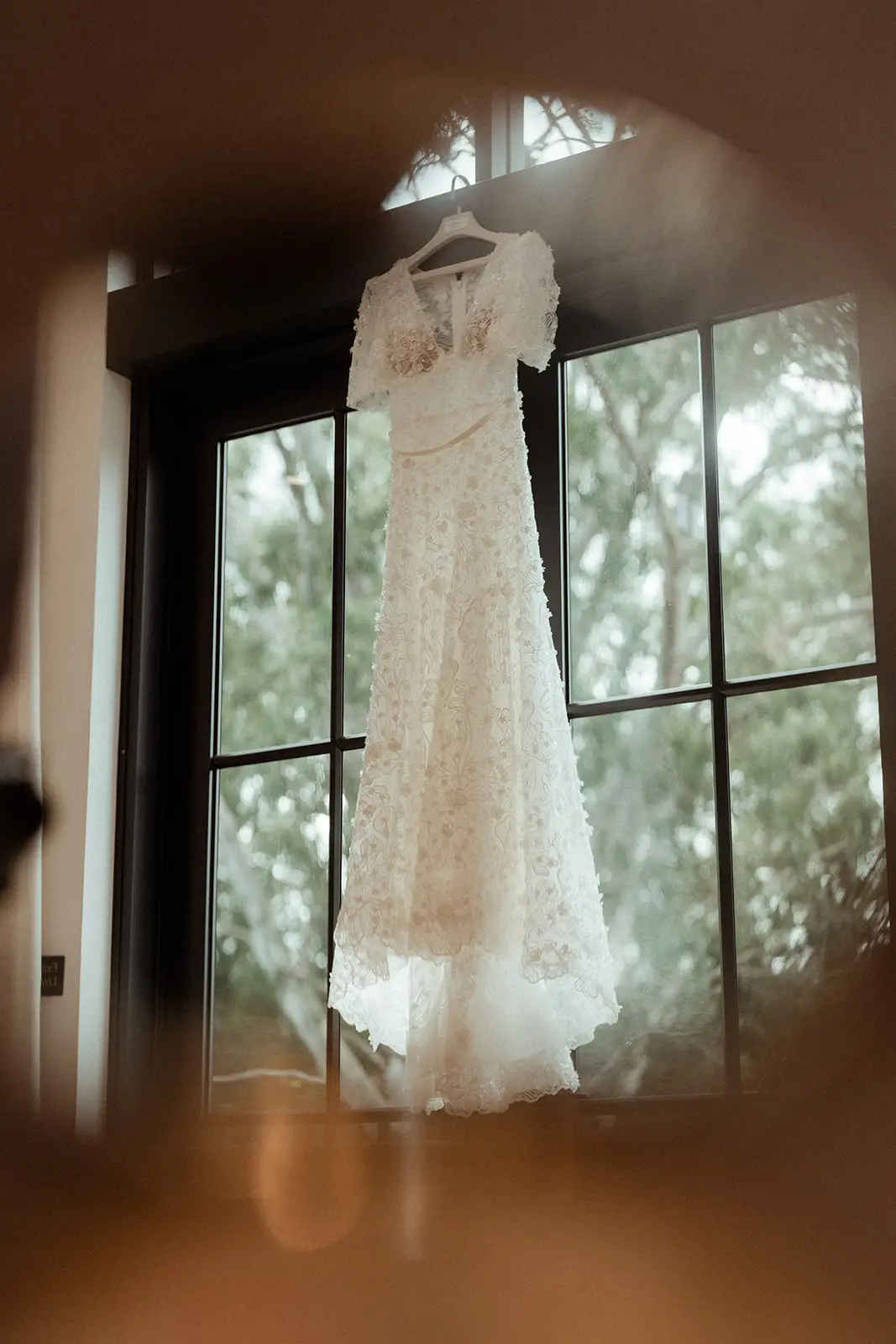 The wedding dress hanging in the arched window of the Sanctuary bridal suite, The Valley Estate