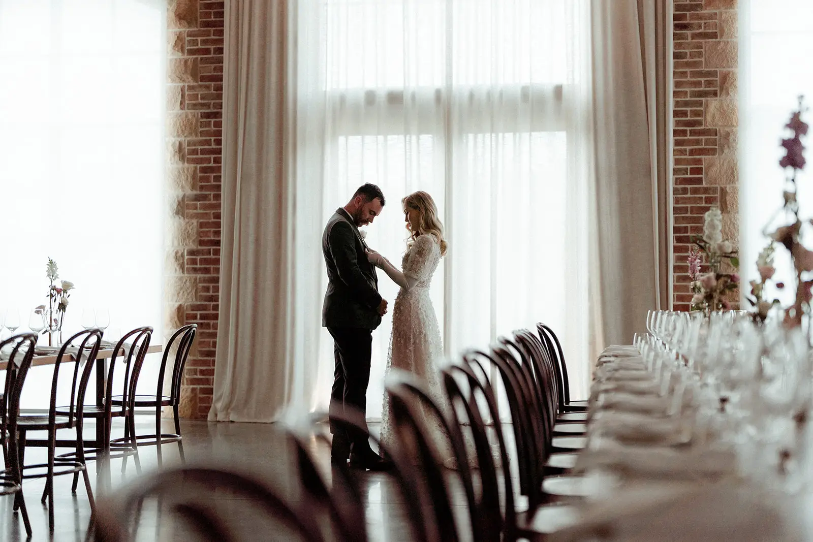 The couple face to face beside the tall curtained windows at the head of the table, The Valley Estate