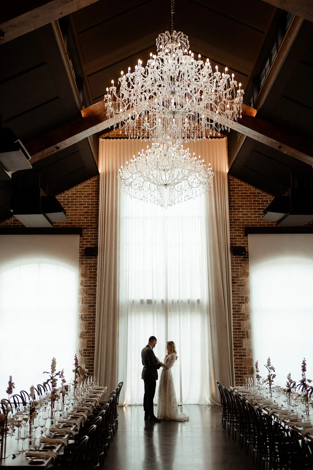 The chandelier and drapes above the aisle, the couple small at the far end, The Valley Estate