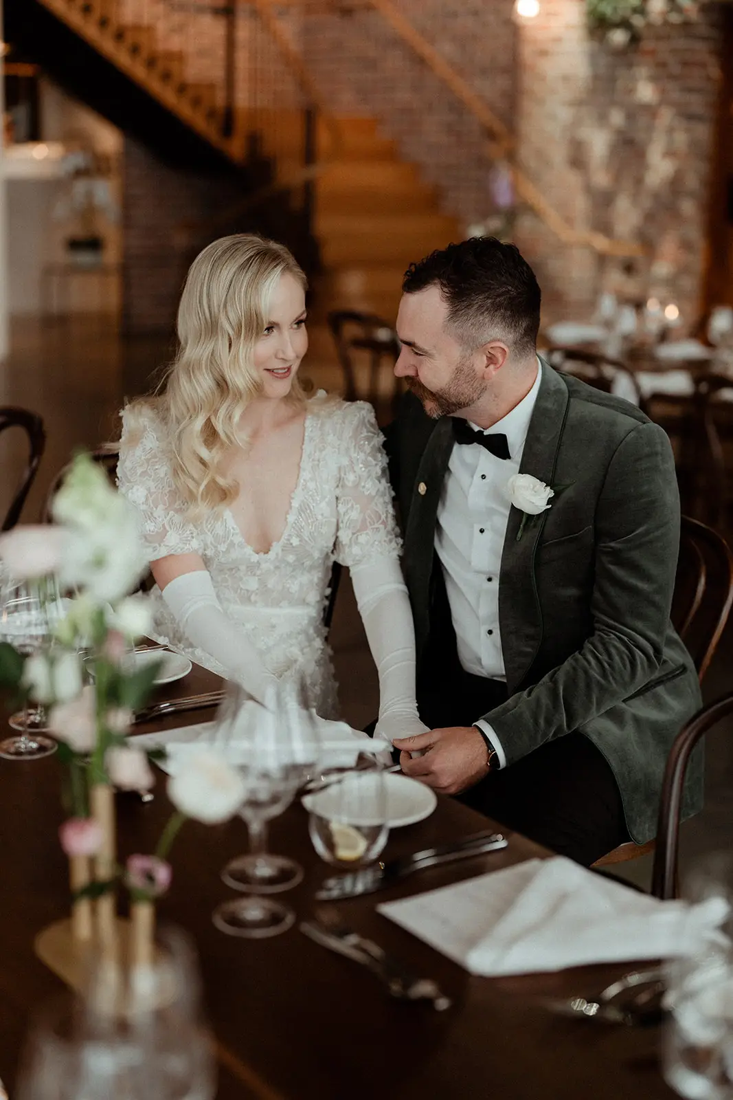 The couple side by side at their table in the brick-walled Manor, The Valley Estate