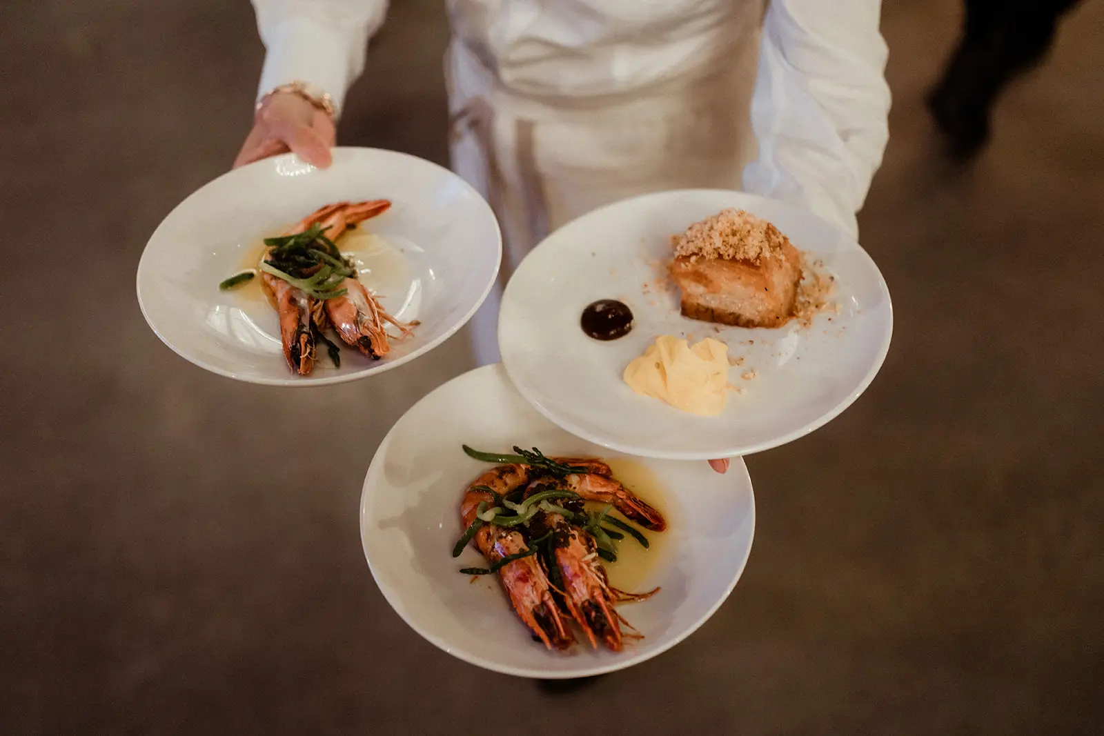 Three plates of prawns and dessert carried through to the tables, The Valley Estate