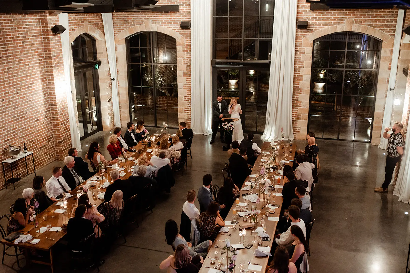 Long tables set the length of the Manor with its red brick walls and tall arched windows, The Valley Estate, Currumbin Valley