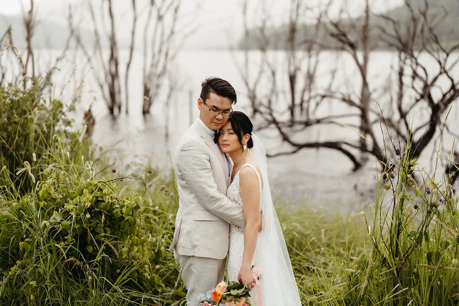 The couple at the water’s edge, drowned trees on the lake behind, The Acre Boomerang Hills